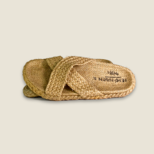 A pair of woven jute flat sandals with braided straps, displayed on a light beige background. The brand name 'HEIDIKIMURU' is printed on the footbed.
